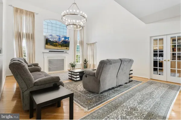a living room with furniture a dining table and a chandelier