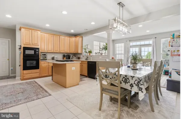 a kitchen with stainless steel appliances granite countertop a table and chairs in it