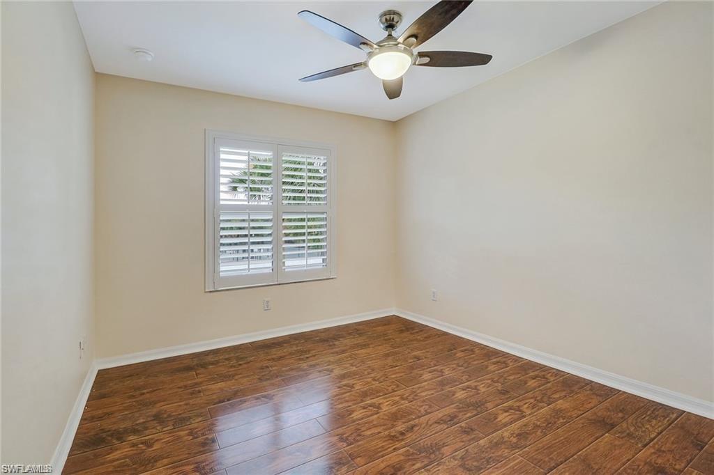 9801 Foxhall Way, Unit 4 Estero, FL 33928 - Photo 11 of 23 Empty room with dark wood-style flooring and ceiling fan