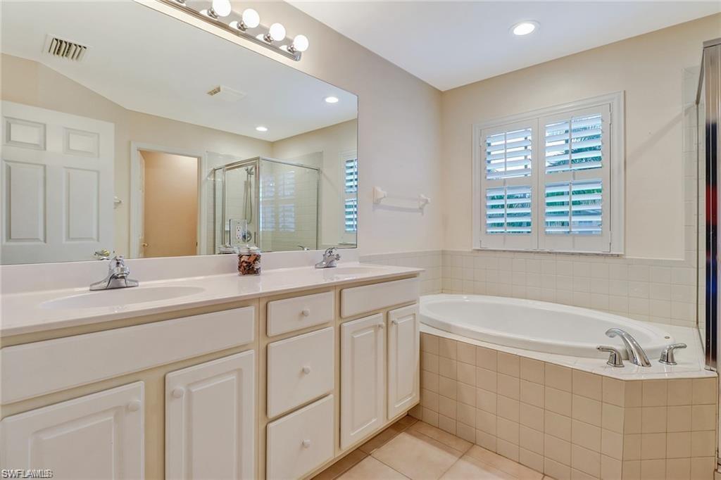 9801 Foxhall Way, Unit 4 Estero, FL 33928 - Photo 10 of 23 Bathroom featuring double vanity, a stall shower, light tile patterned flooring, a bath, and recessed lighting