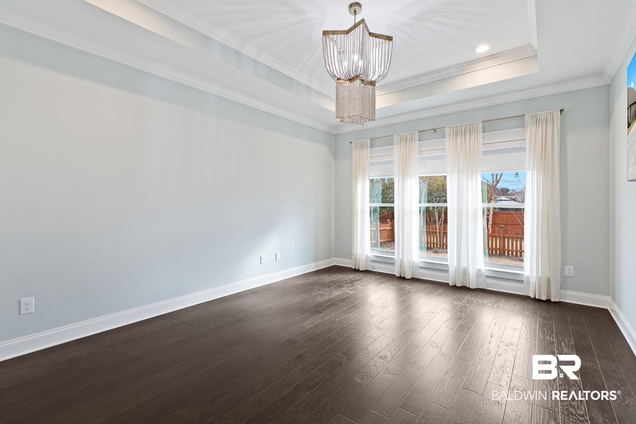 31654 Canopy Loop Daphne, AL 36527 - Photo 28 of 64 Spare room featuring hanging lights, dark wood finished floors, crown molding, and a tray ceiling