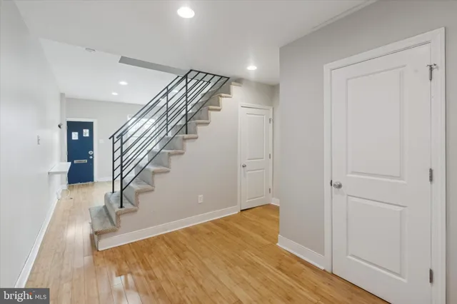 a view of a hallway with wooden floor and staircase