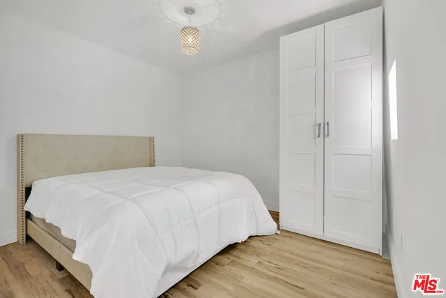 a bedroom with a bed and wooden floor