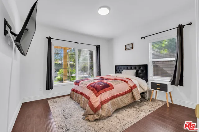 a bedroom with a bed lamp and a large window