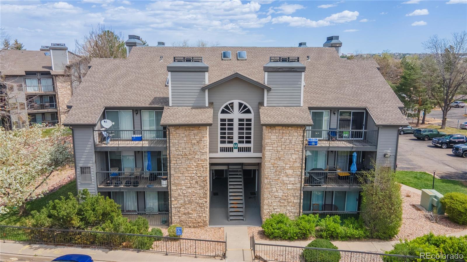 2575 South Syracuse Way, Unit M206 Denver, CO 80231 - Photo 19 of 24 a front view of a house with plants and garden