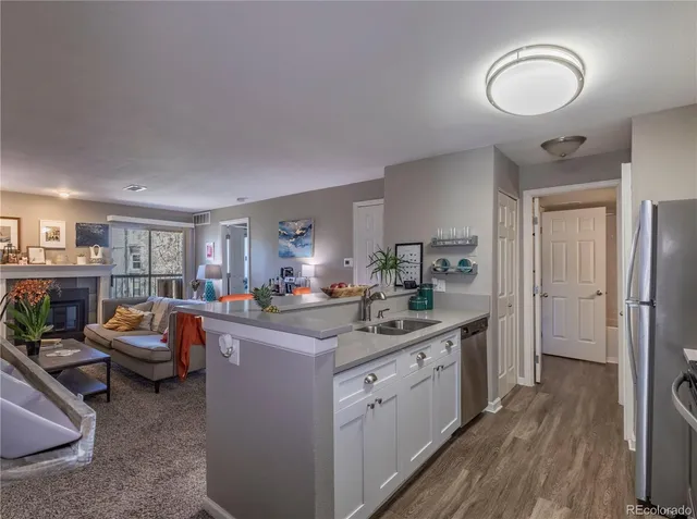 a kitchen with a sink a refrigerator and a stove top oven