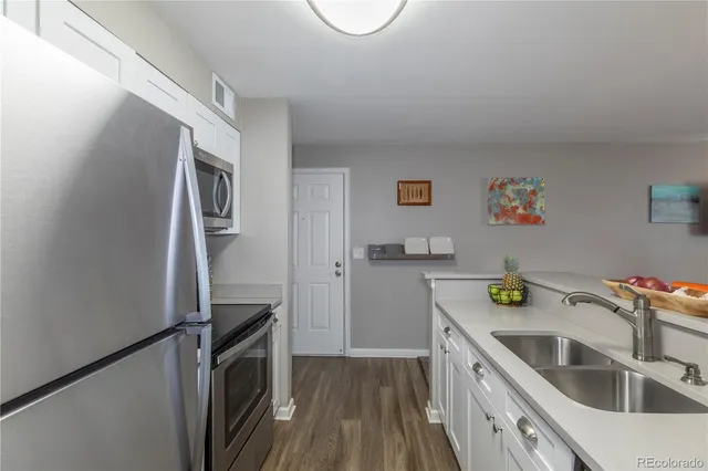 a kitchen with granite countertop cabinets stainless steel appliances and wooden floor