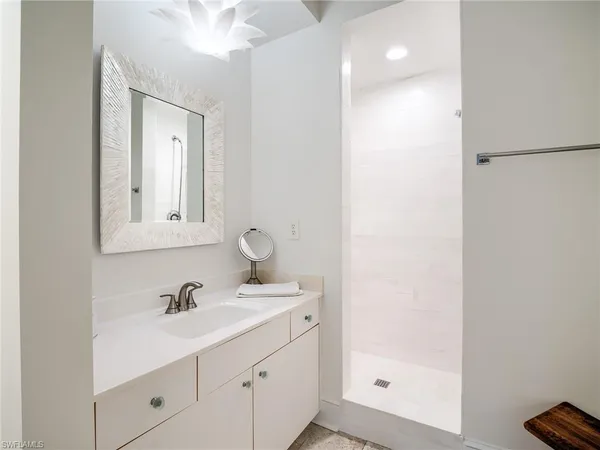 a bathroom with a sink a shower and a mirror