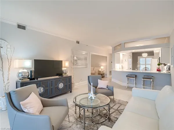 a living room with furniture a dining table and kitchen view