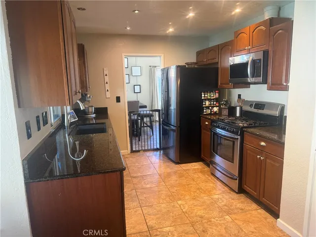 a kitchen with stainless steel appliances granite countertop a refrigerator and a stove