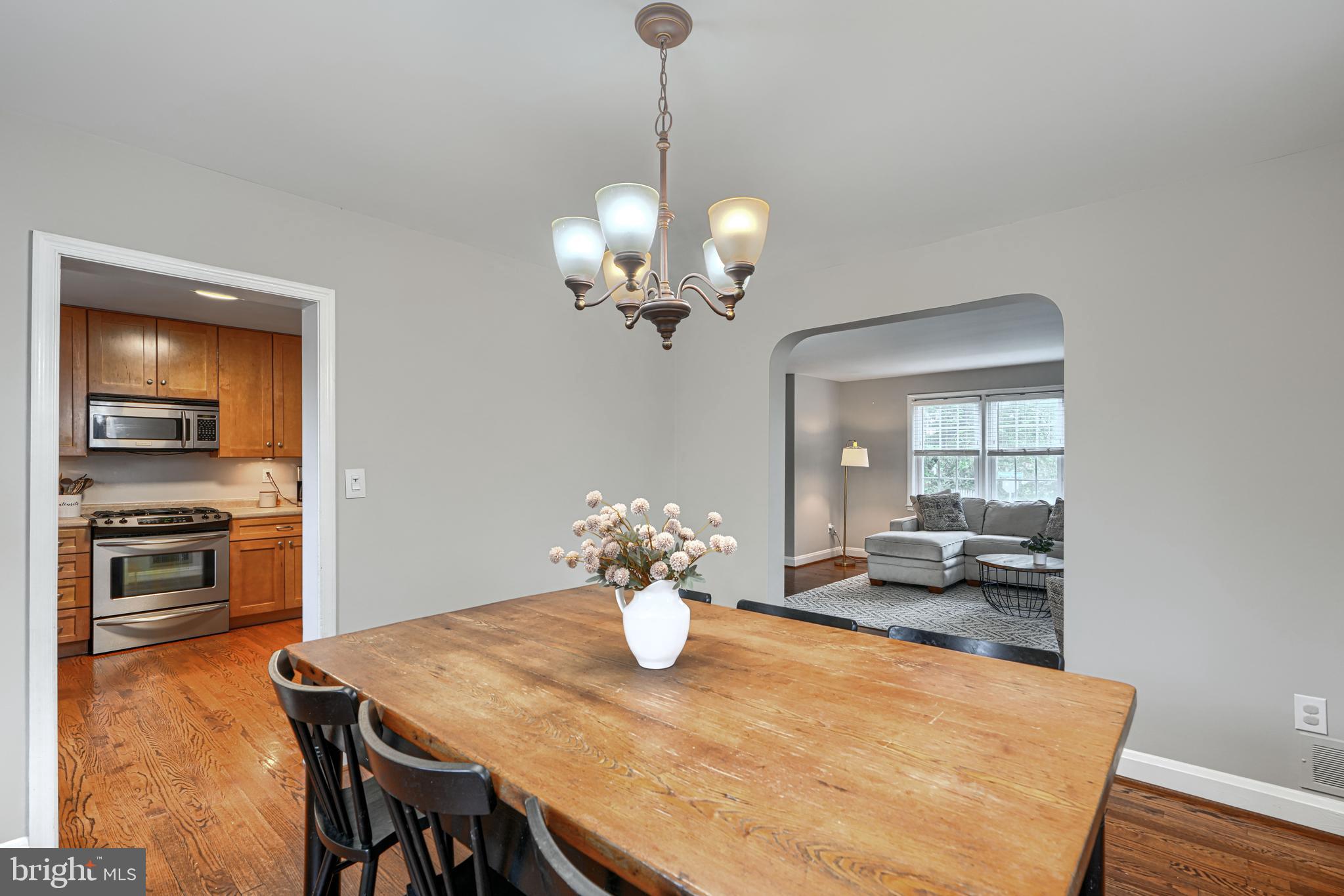 8132 Pleasant Plains Road Towson, MD 21286 - Photo 12 of 55 a dining room with wooden floor a chandelier a wooden table and chairs