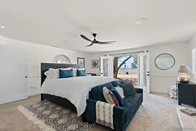 a bedroom with a large bed and a chandelier