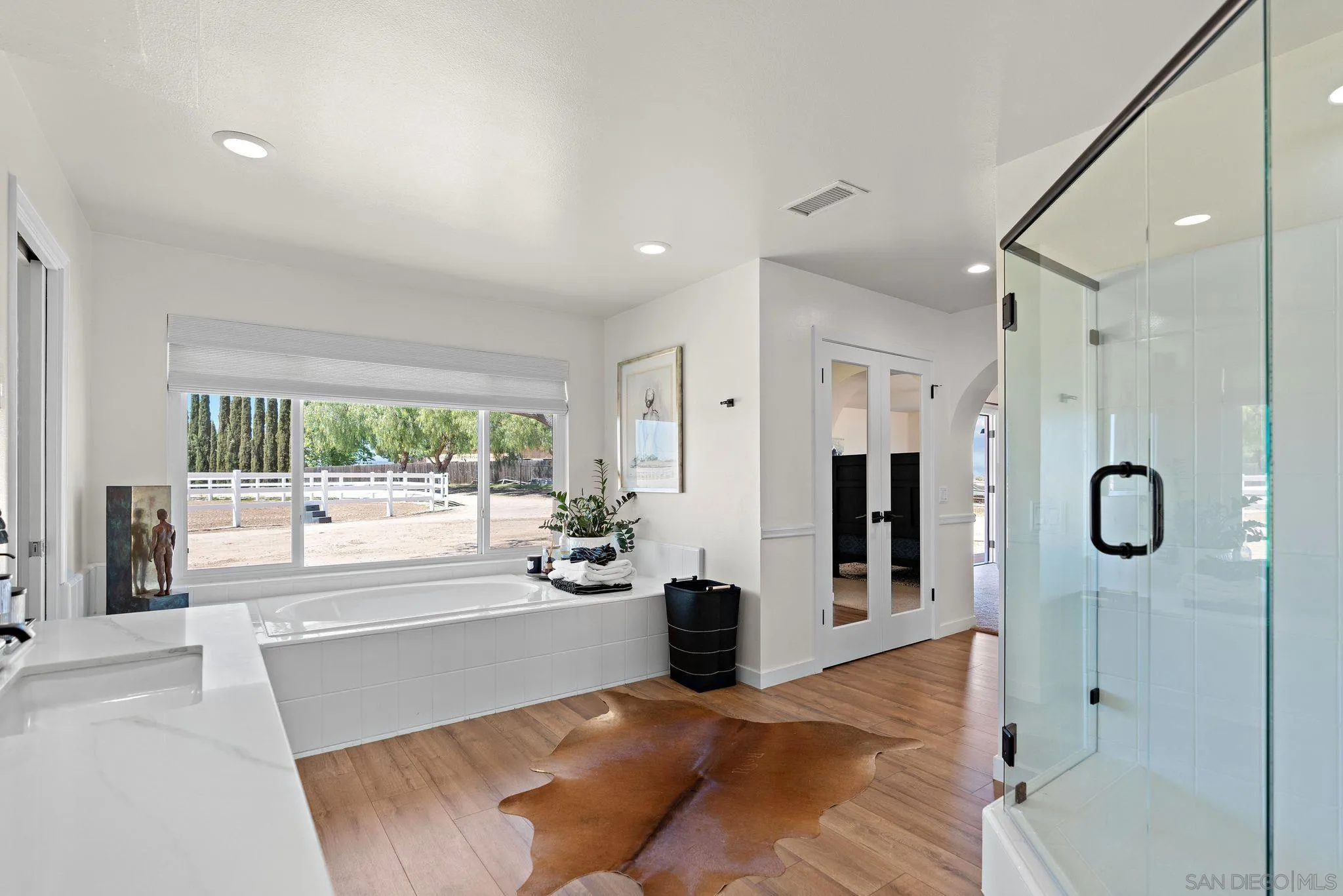 34020 Madera De Playa Drive Temecula, CA 92592 - Photo 12 of 24 a large white bathroom with a tub shower and mirror