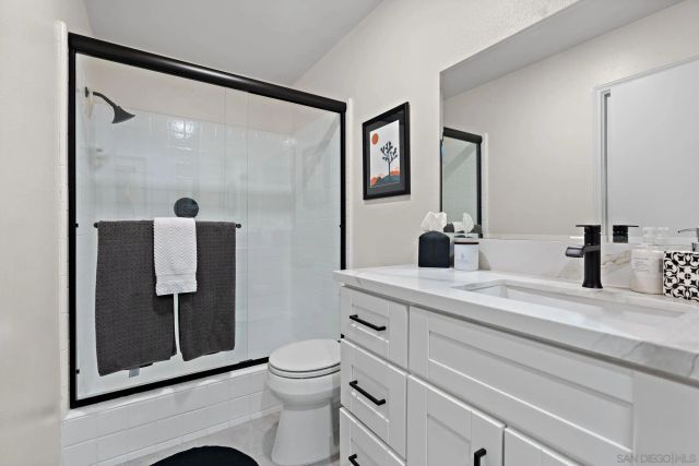 a bathroom with a toilet a sink and glass door