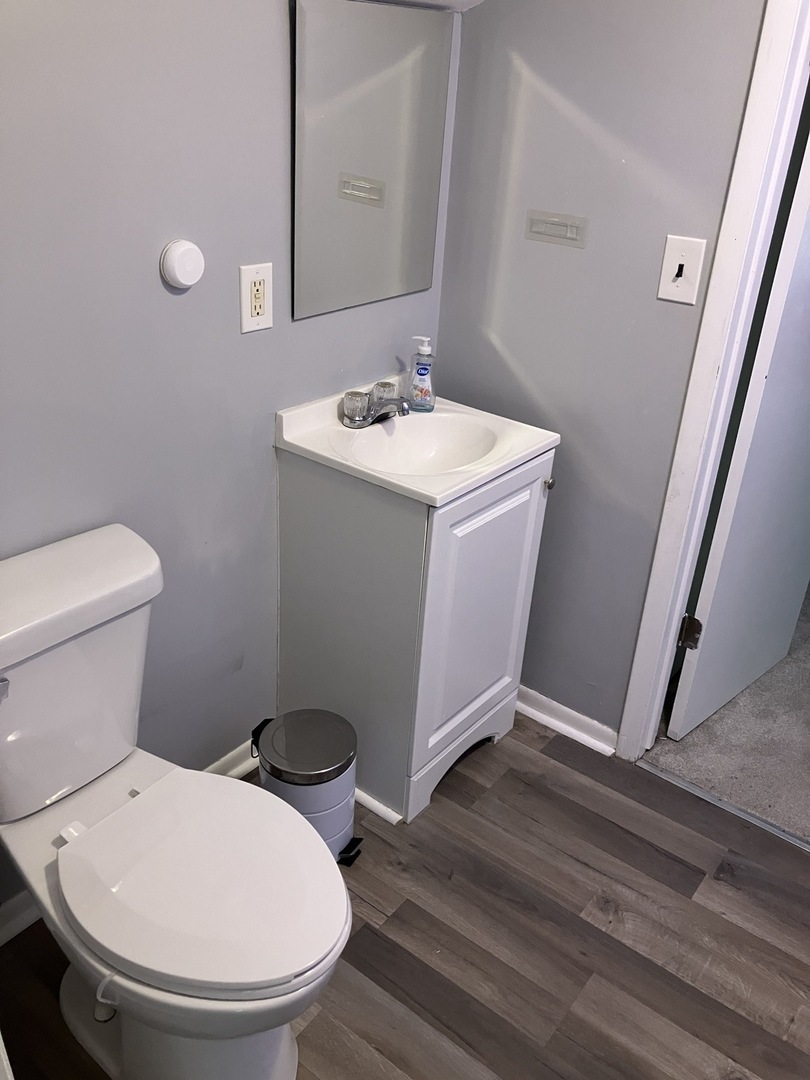 1432 Ridgeway Street Round Lake Beach, IL 60073 - Photo 16 of 20 a bathroom with a toilet sink and mirror