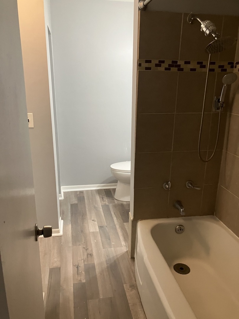 1432 Ridgeway Street Round Lake Beach, IL 60073 - Photo 8 of 20 a bathroom with a tub a toilet and a sink