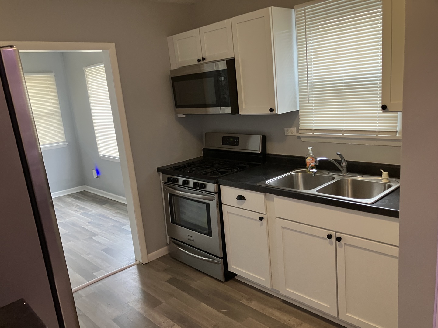 1432 Ridgeway Street Round Lake Beach, IL 60073 - Photo 10 of 20 a kitchen with granite countertop white cabinets and black appliances