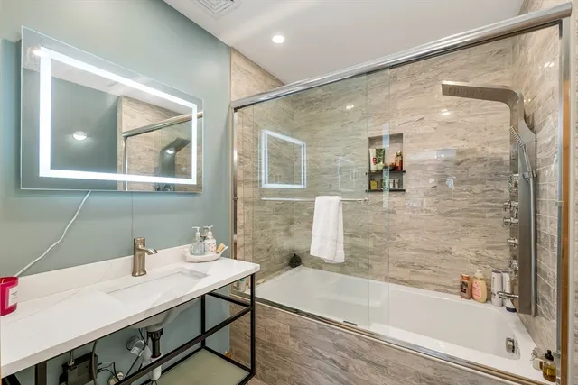 a bathroom with a bathtub a sink and a mirror