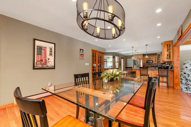 a view of a dining room with furniture a chandelier and wooden floor