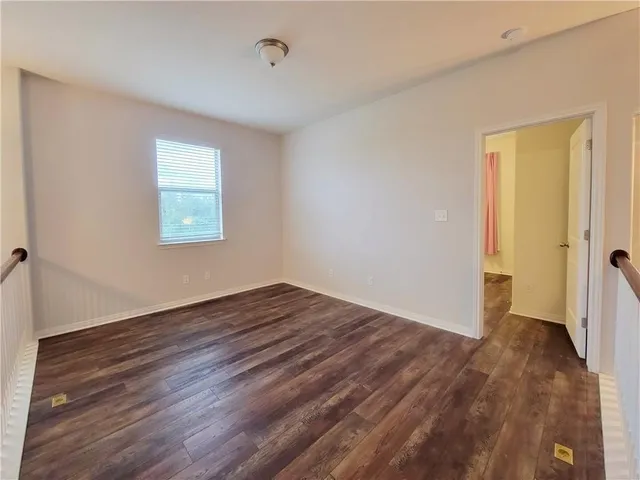 an empty room with wooden floor and a window