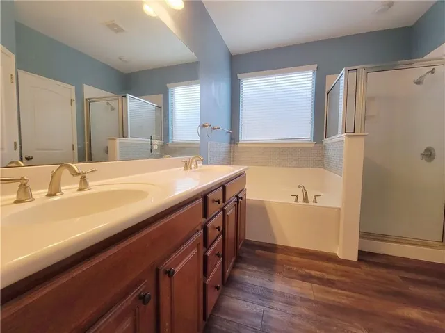 a bathroom with a tub sink and mirror