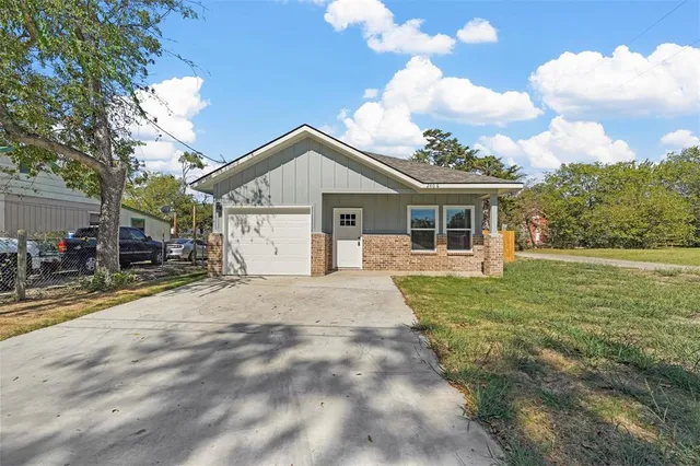 a view of a house with a yard and garage