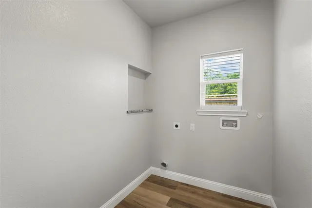 a view of a small space with wooden floor and a window