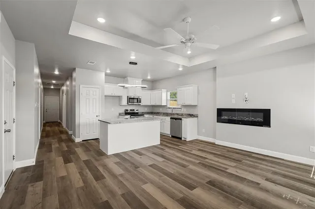 a large kitchen with kitchen island a sink stainless steel appliances and cabinets