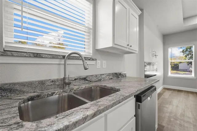 a kitchen with granite countertop a sink and a window