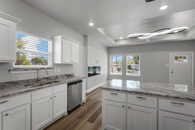 a kitchen with granite countertop cabinets stainless steel appliances a sink and a window