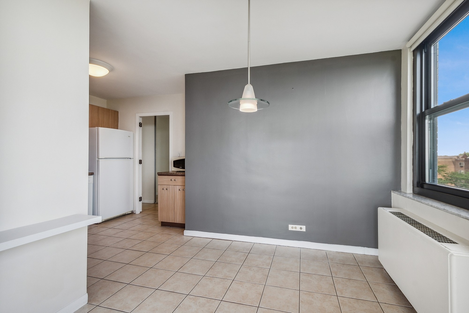 5701 North Sheridan Road, Unit 5K Chicago, IL 60660 - Photo 11 of 24 an empty room with a fireplace and a window