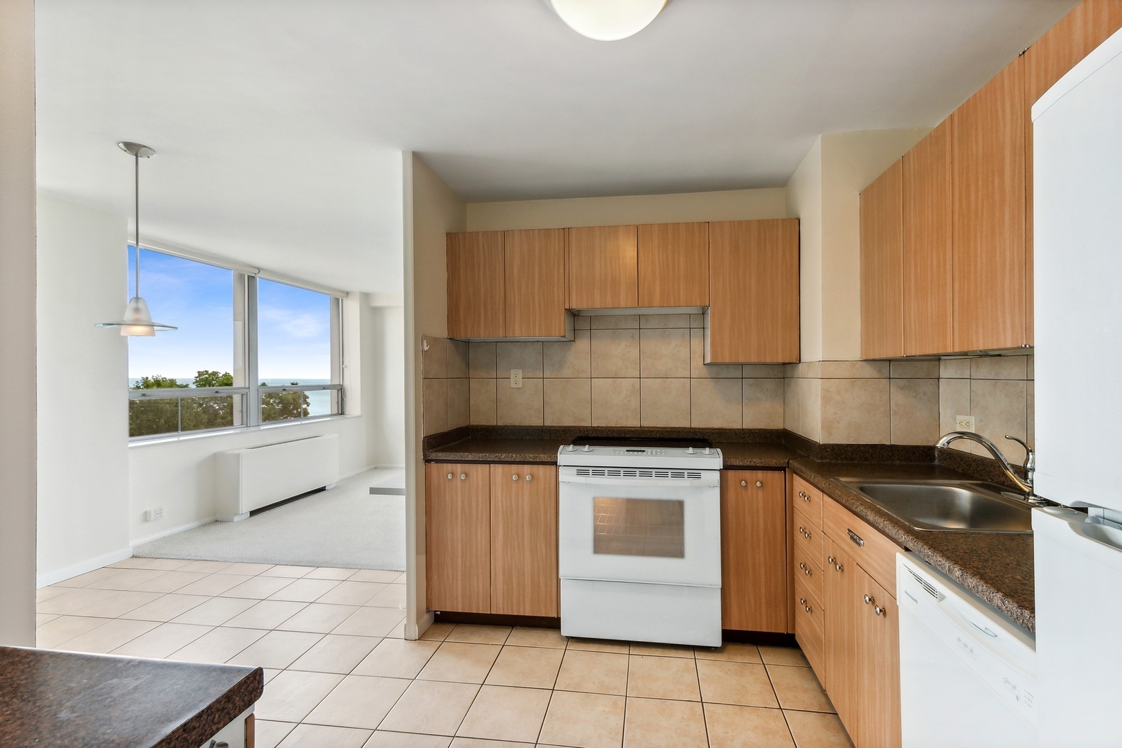 5701 North Sheridan Road, Unit 5K Chicago, IL 60660 - Photo 12 of 24 a kitchen with a stove a sink and a refrigerator