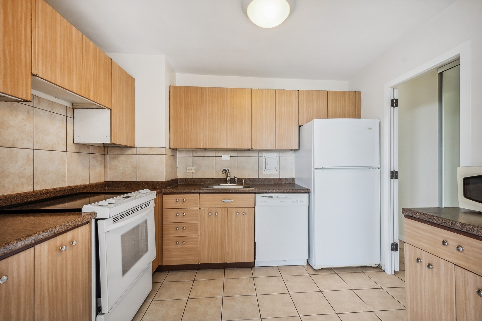 5701 North Sheridan Road, Unit 5K Chicago, IL 60660 - Photo 13 of 24 a kitchen with a stove a refrigerator and white cabinets