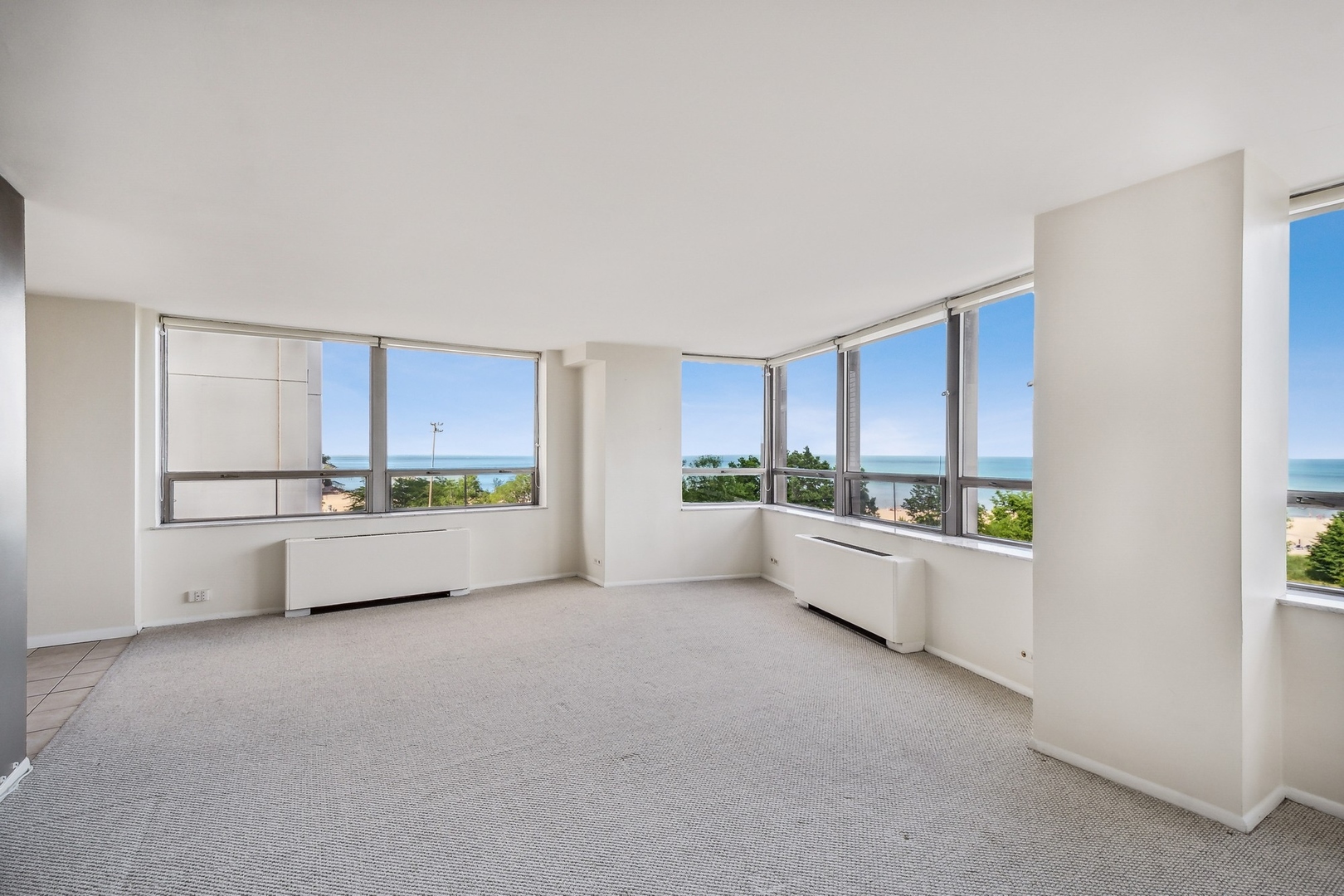 5701 North Sheridan Road, Unit 5K Chicago, IL 60660 - Photo 6 of 24 a large white room with a large window and white cabinets