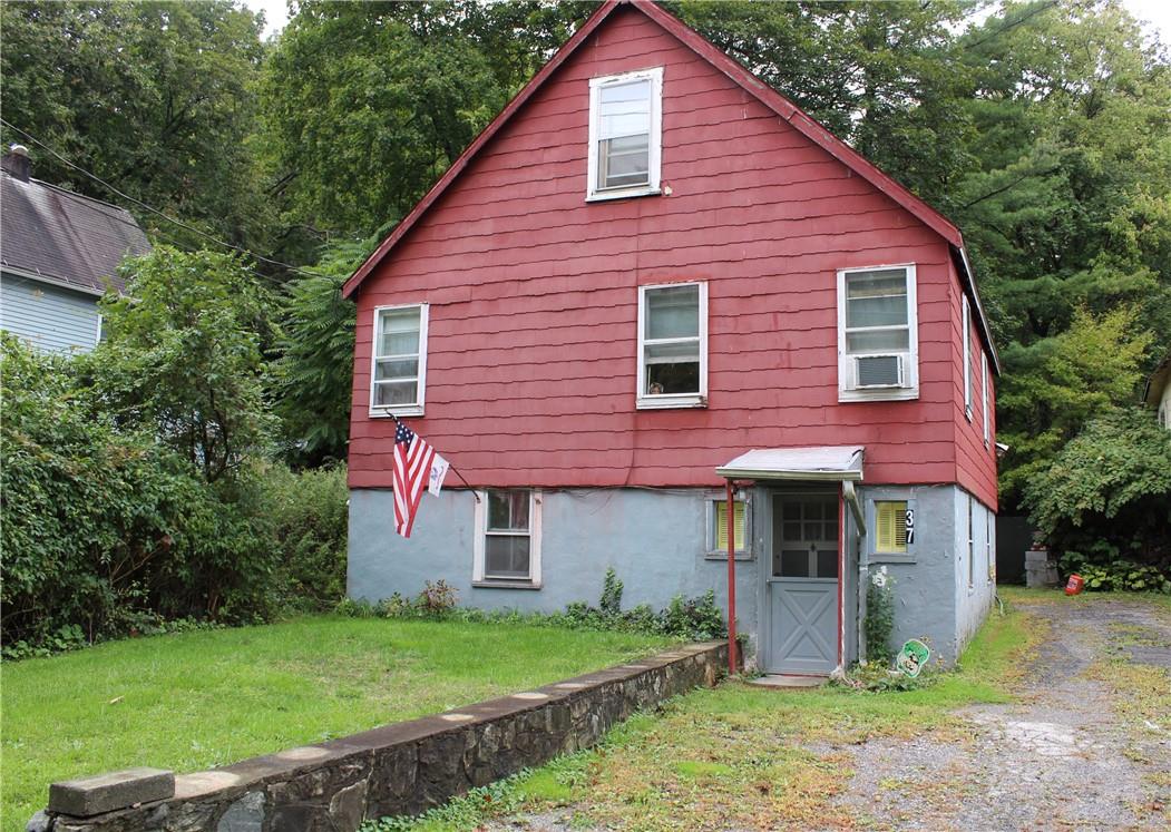 a front view of a house with a yard and trees
