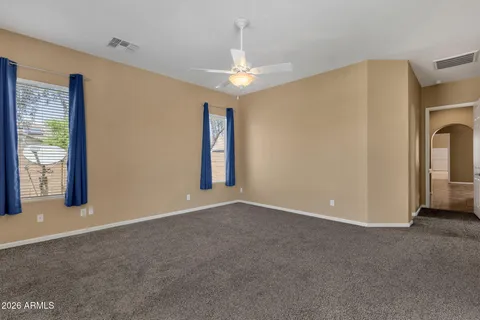 a view of an empty room with window and chandelier