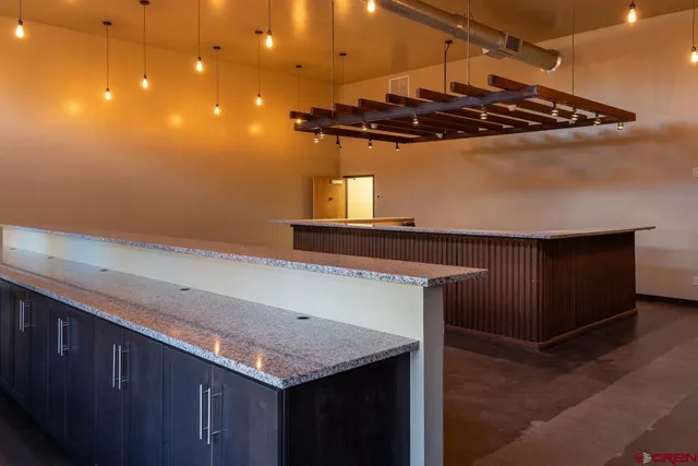 a kitchen with a sink a counter space and wooden floor
