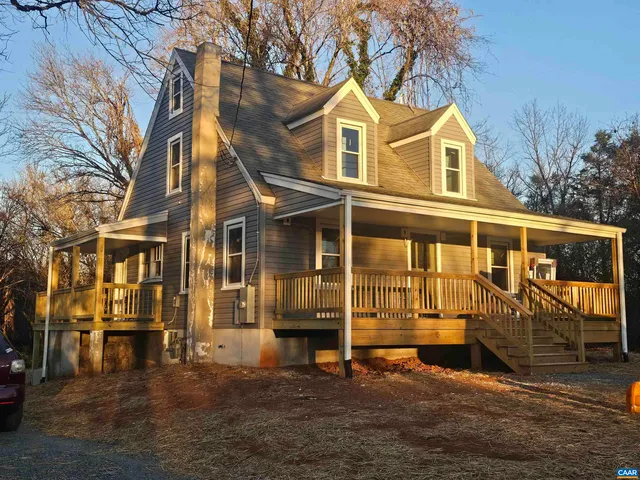 a front view of a house with a yard outdoor seating and mountain view