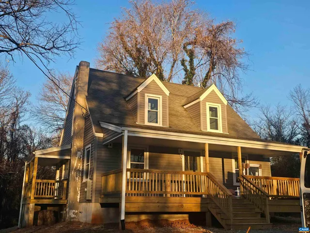 a front view of a house with a tree