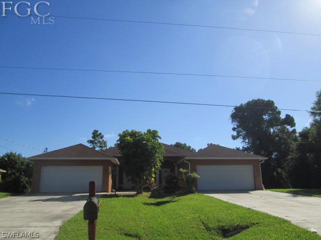 113 Meadow Road Lehigh Acres, FL 33973 - Photo 1 of 10 a front view of a house with garden