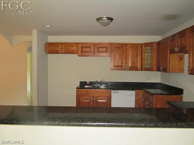 113 Meadow Road Lehigh Acres, FL 33973 - Photo 3 of 10 a kitchen with granite countertop a stove a sink and a microwave