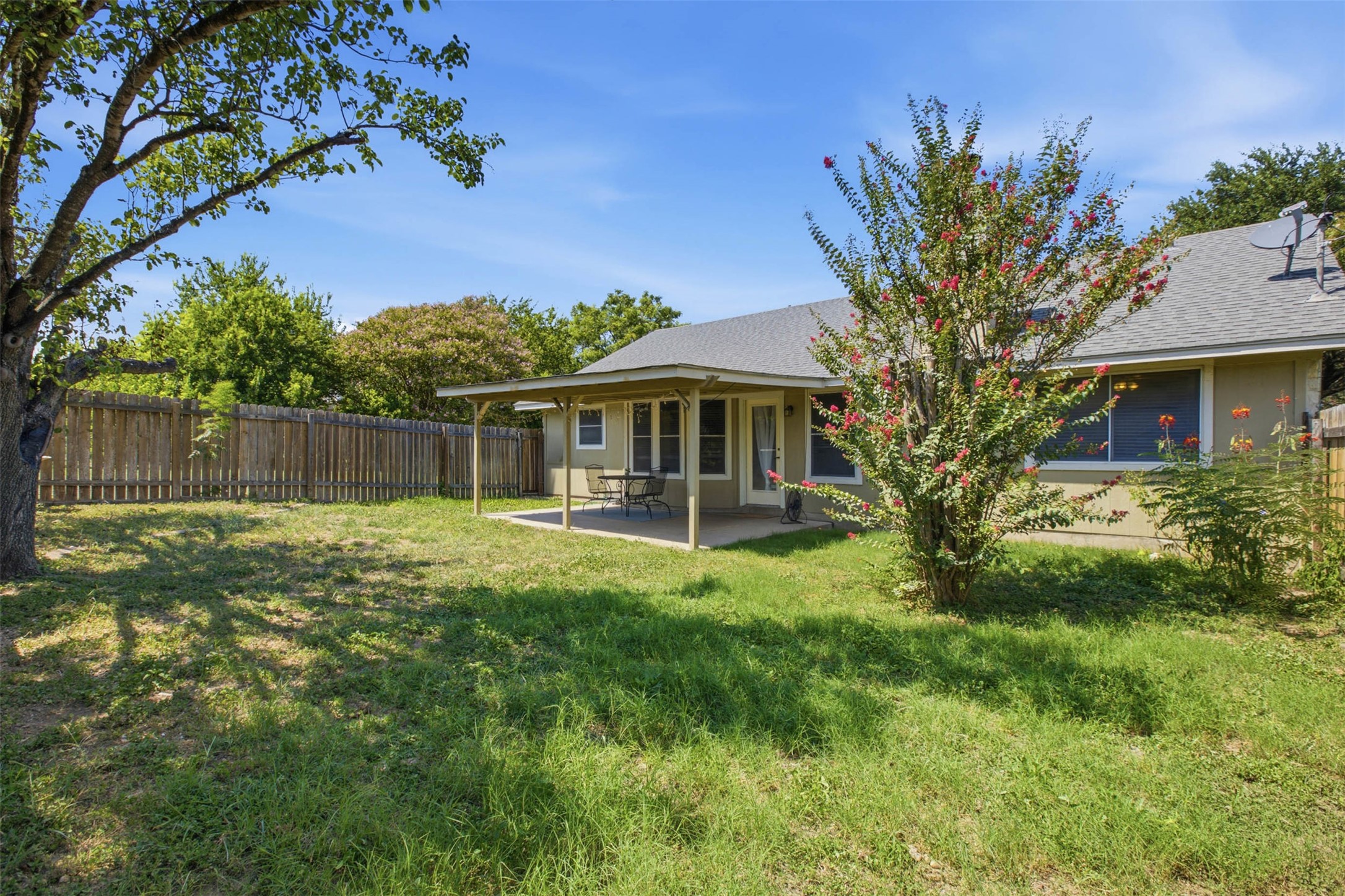 1717 Rendova Lane Pflugerville, TX 78660 - Photo 23 of 32 A spacious backyard with a private wooden fence and a covered patio for outdoor relaxation.
