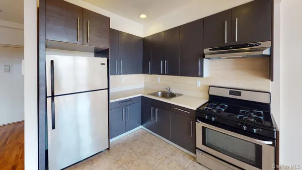 a kitchen with stainless steel appliances granite countertop a refrigerator sink and stove