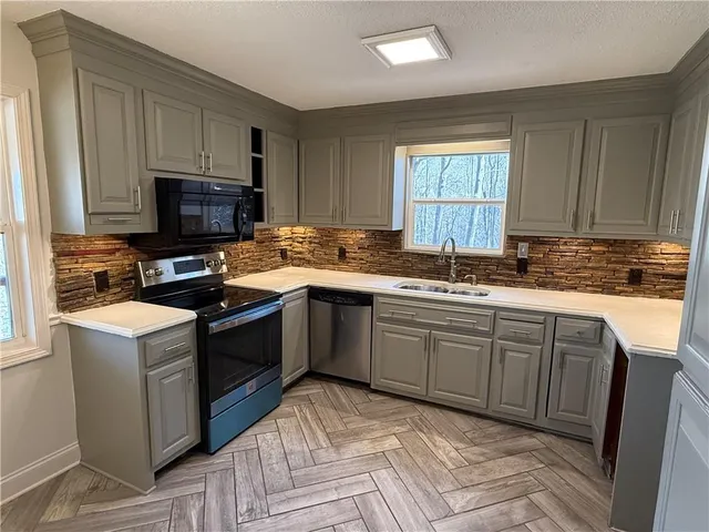 a kitchen with a sink stove top oven and microwave