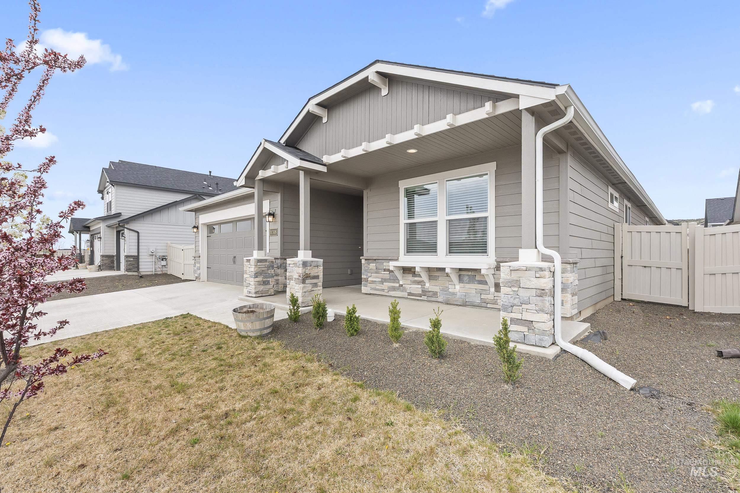 10308 West Trident Ridge Drive Star, ID 83669 - Photo 3 of 42 Craftsman inspired home with stone siding, concrete driveway, a porch, a gate, and a garage