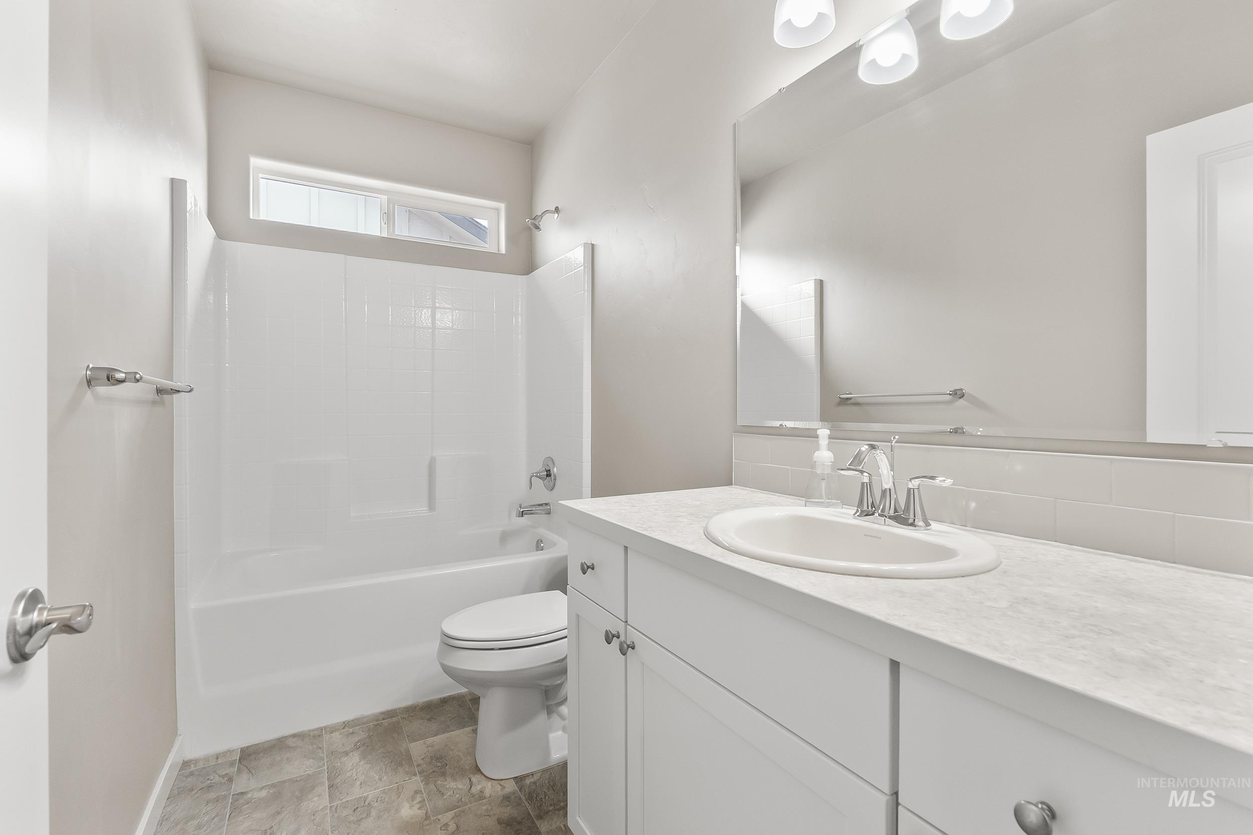 10308 West Trident Ridge Drive Star, ID 83669 - Photo 31 of 42 Full bath featuring vanity, shower / tub combination, stone finish flooring, and decorative backsplash