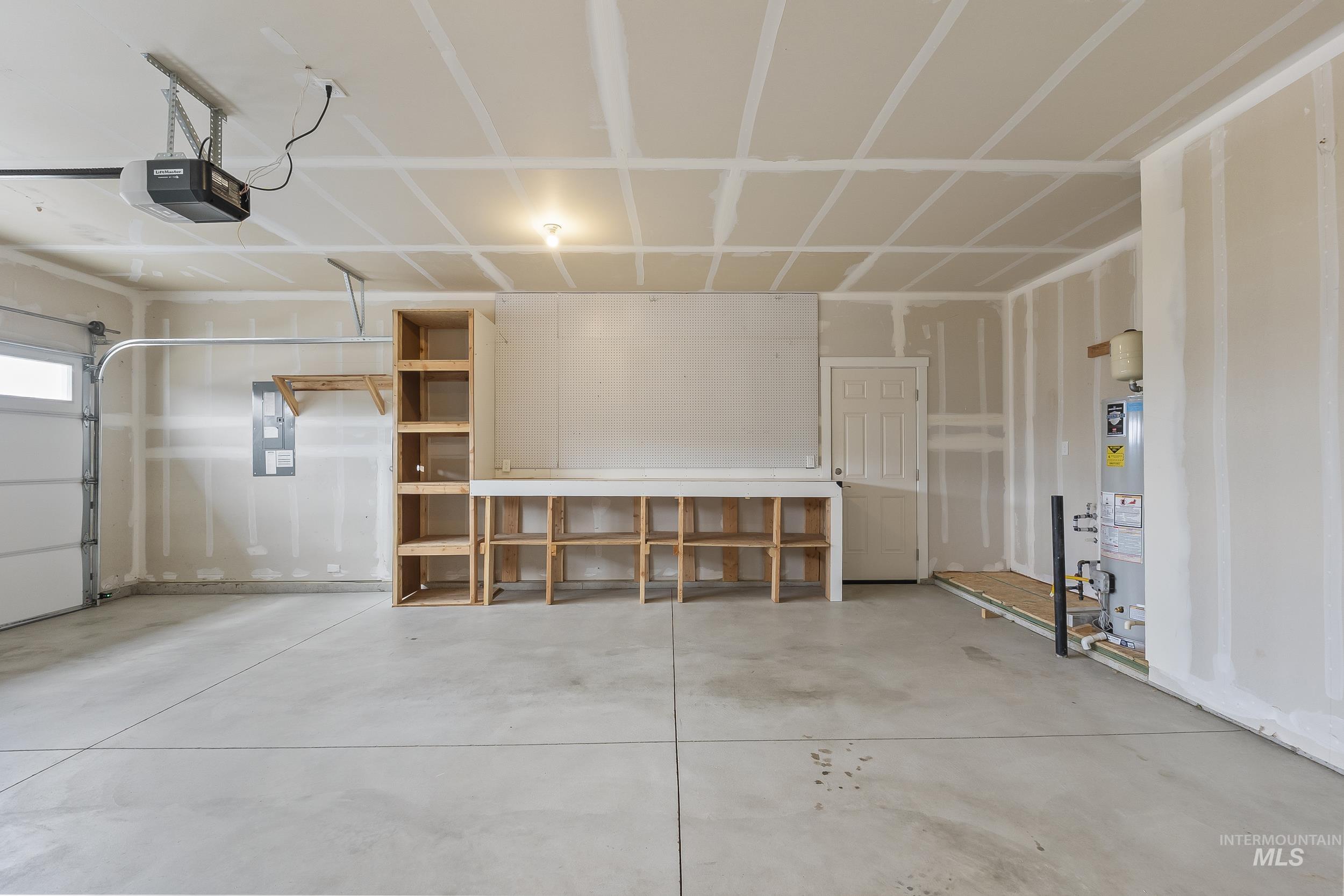 10308 West Trident Ridge Drive Star, ID 83669 - Photo 37 of 42 Garage featuring electric panel, a garage door opener, and gas water heater