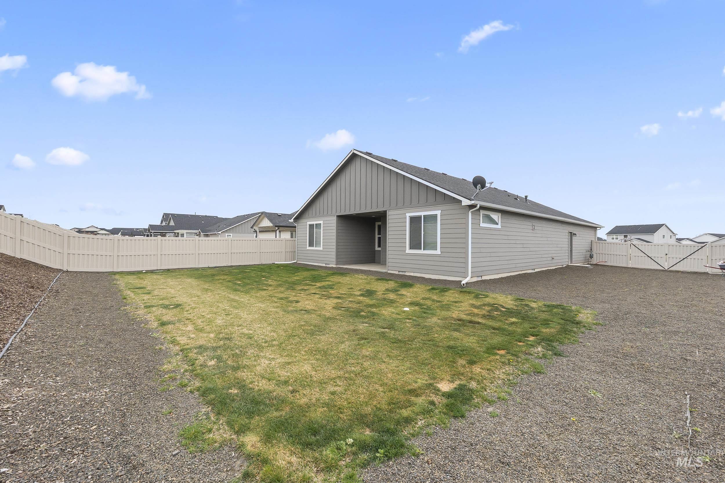 10308 West Trident Ridge Drive Star, ID 83669 - Photo 40 of 42 Back of house with board and batten siding, a patio, and a fenced backyard