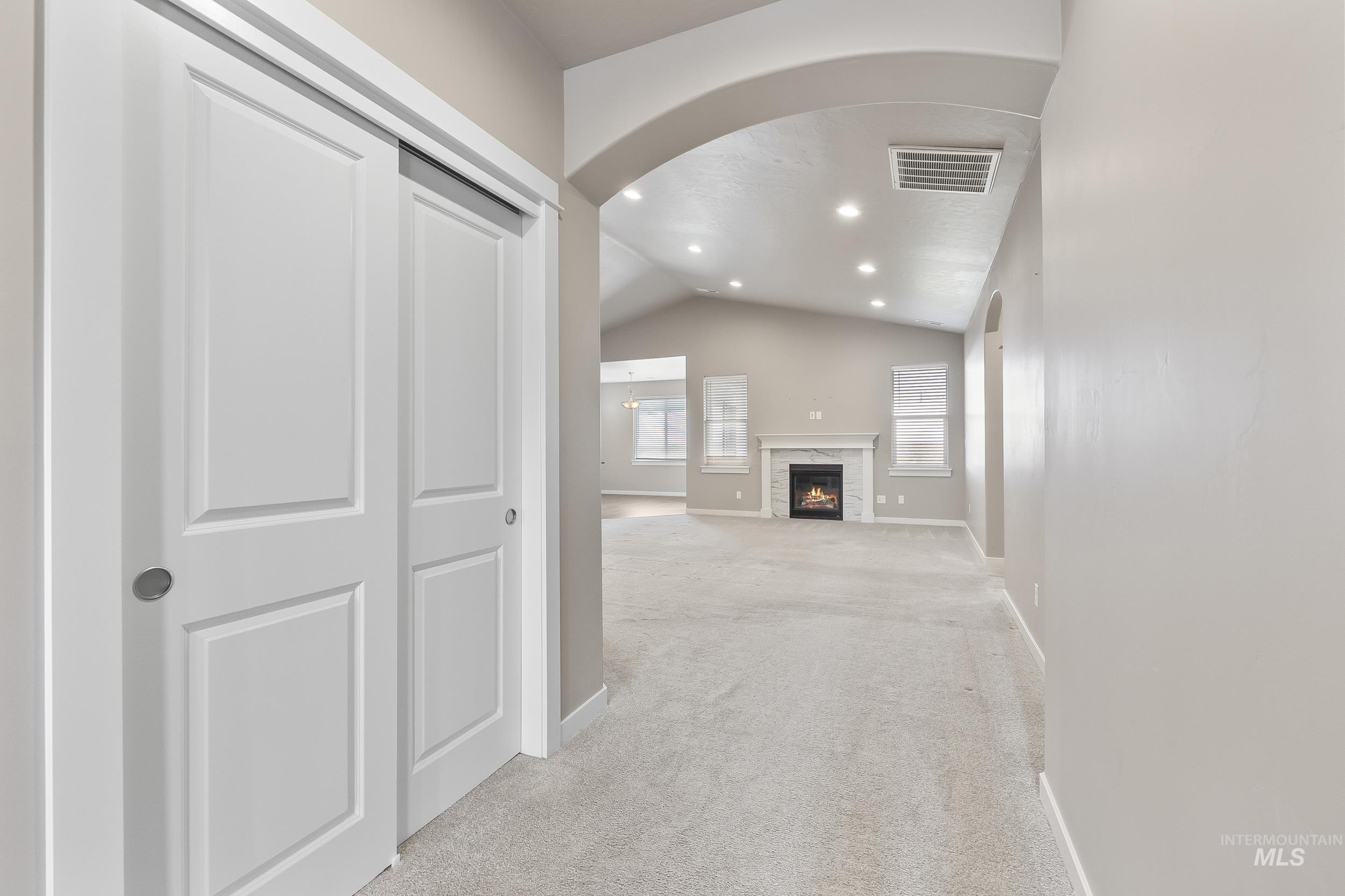 10308 West Trident Ridge Drive Star, ID 83669 - Photo 7 of 42 Corridor with vaulted ceiling, recessed lighting, light colored carpet, and arched walkways