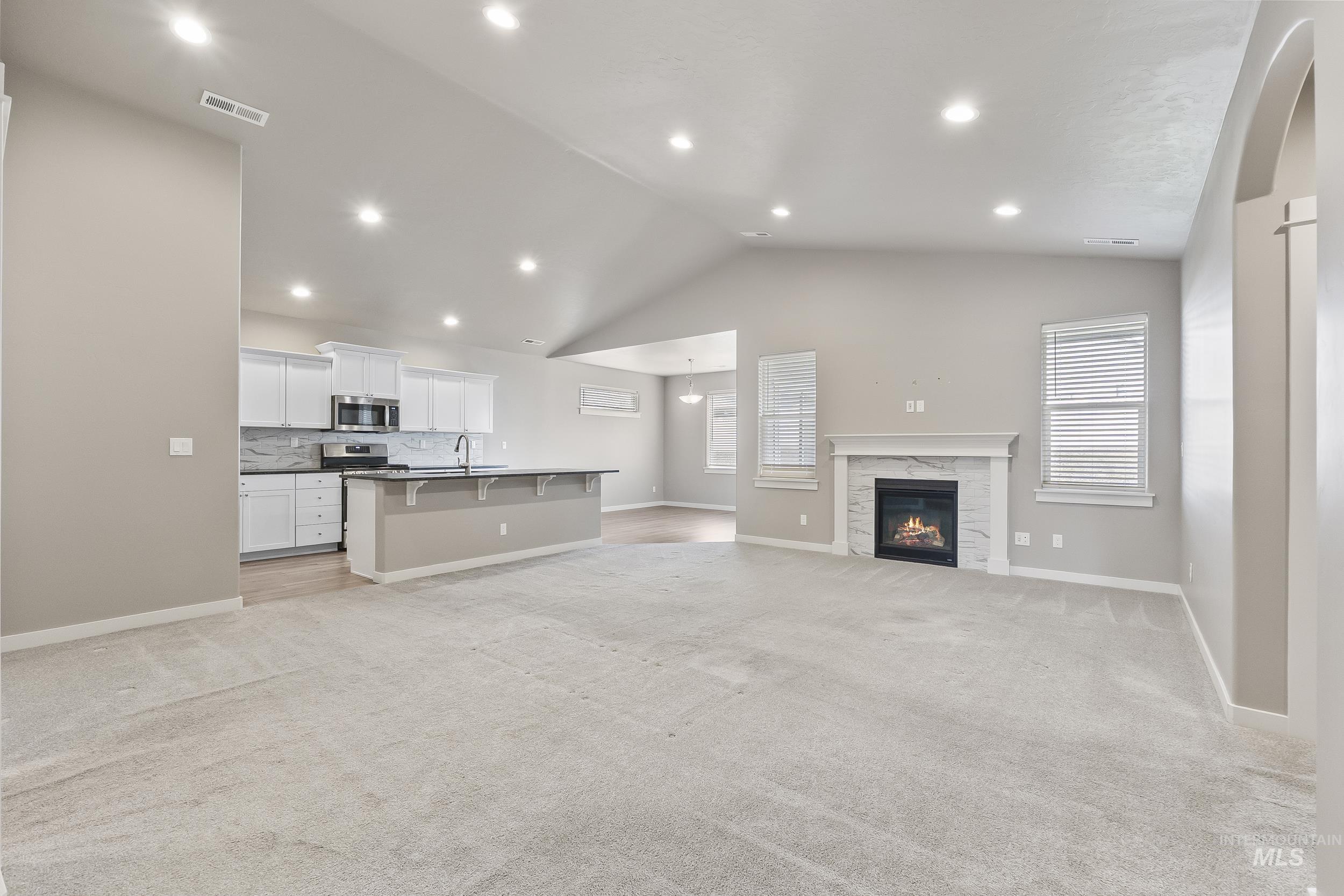 10308 West Trident Ridge Drive Star, ID 83669 - Photo 8 of 42 Unfurnished living room featuring light carpet, a high end fireplace, and recessed lighting